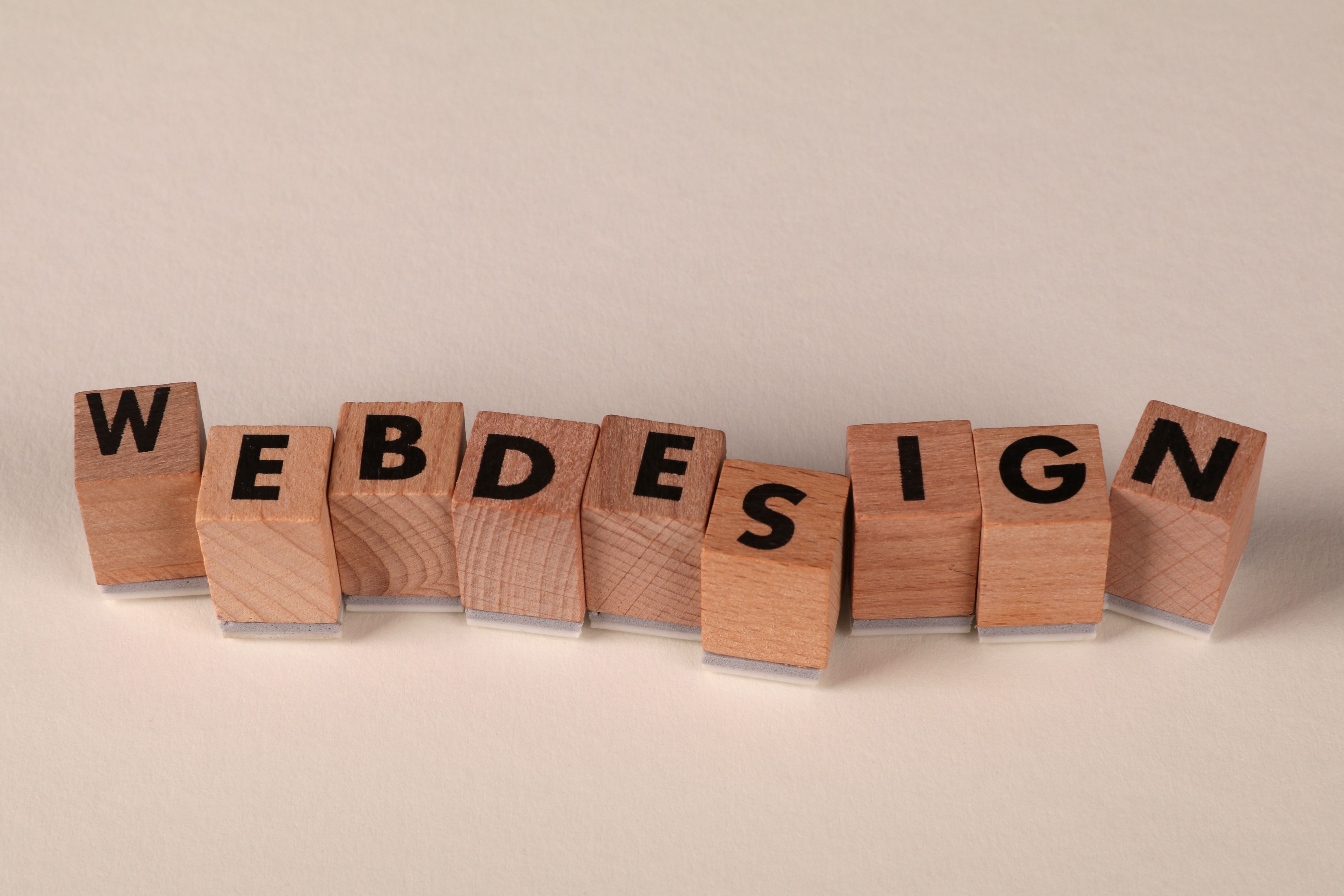 Wooden letter blocks spelling WEB DESIGN — Quam Code website design work